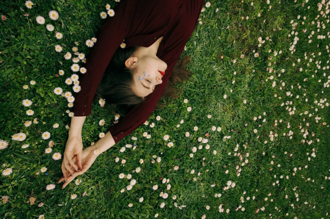 Woman resting in lush green field after taking CBD